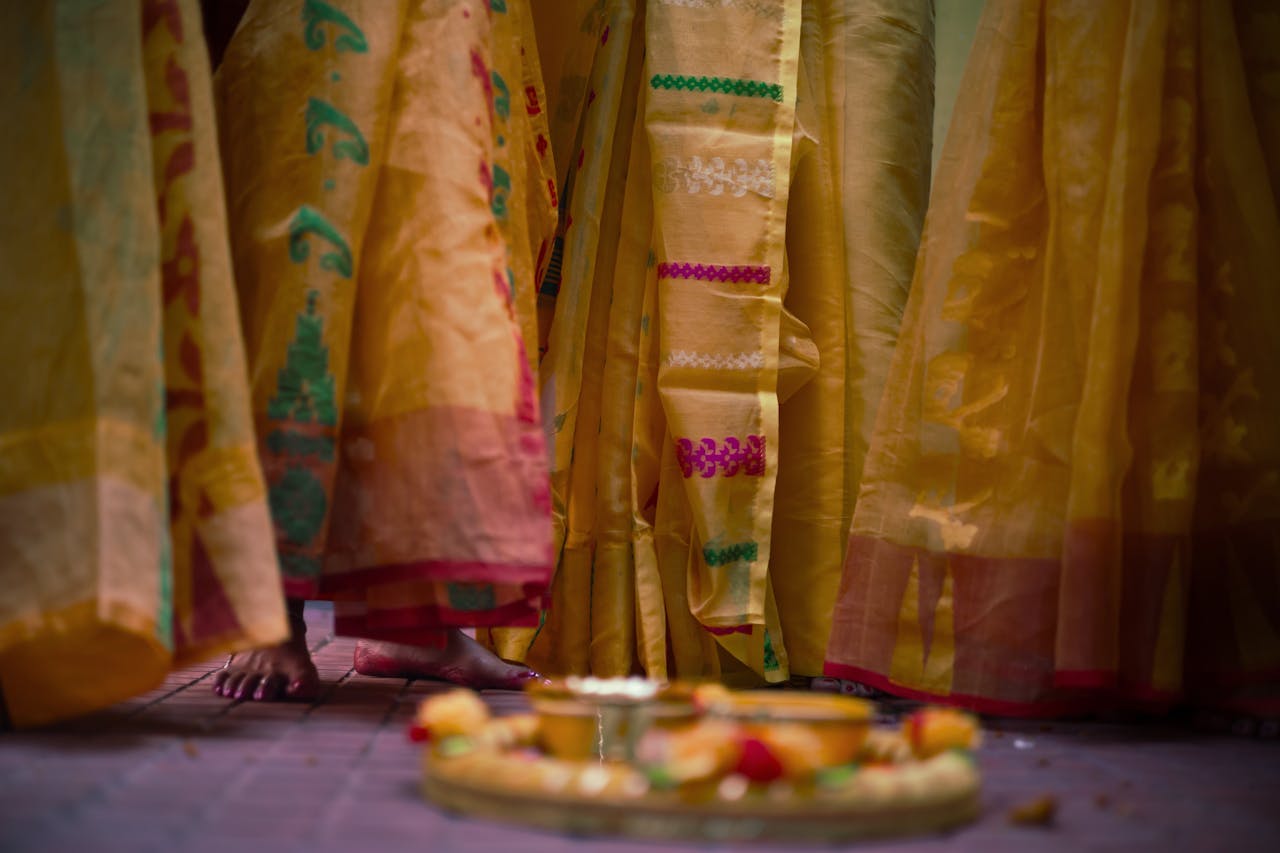 Festive scene depicting feet and sarees of women in traditional attire