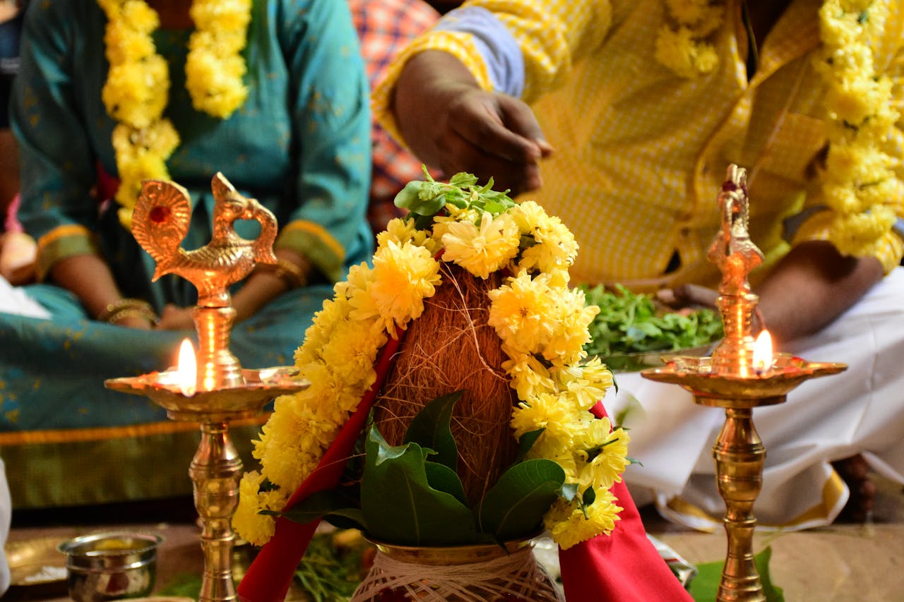 Close-up of a traditional Tamil ceremony with vibrant yellow flowers and oil lamps